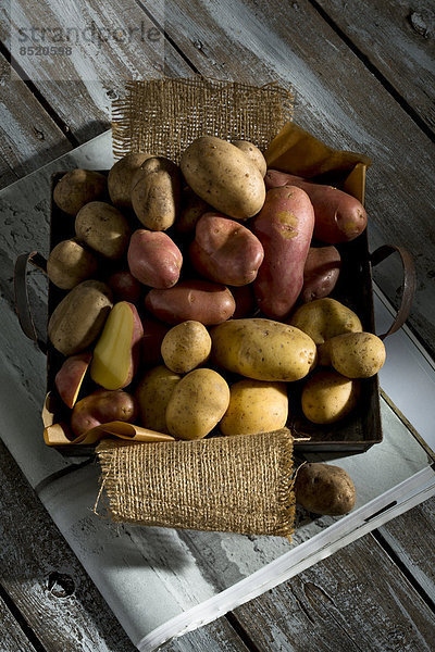 Different sorts of organic potatoes on metal tray