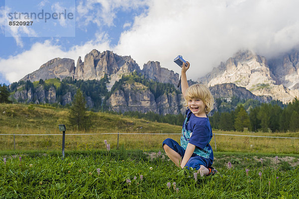 Italien  Provinz Belluno  ßeneto  Cortina d'Ampezzo  lachender kleiner Junge hält Kamera