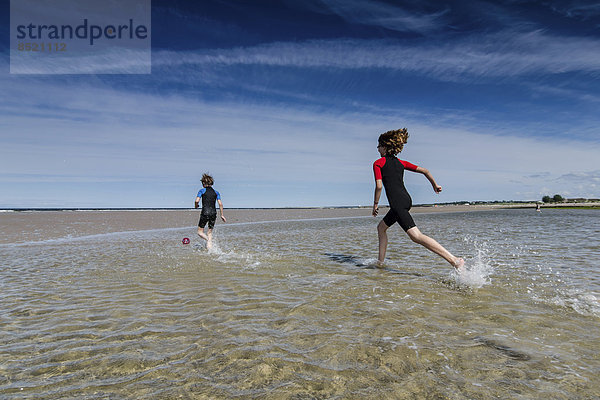 UK  Schottland  Burghead Bay  Kinder  die im Wasser laufen