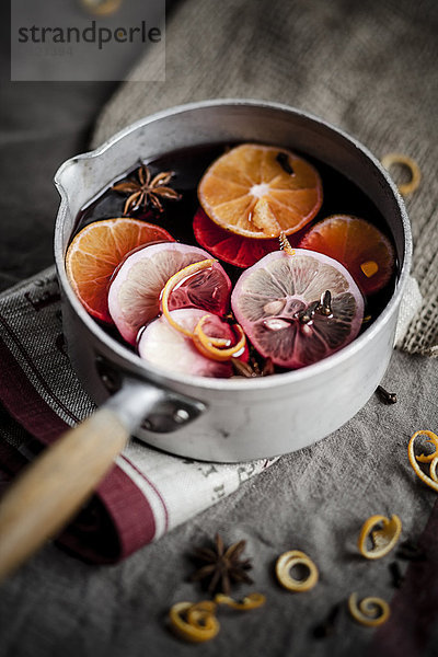 Casserole with mulled wine  slices of lemons and oranges and spices