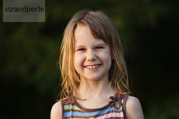 Porträt eines lächelnden kleinen Mädchens bei Sonnenschein