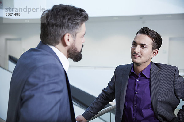 Germany  Neuss  Businessmen talking in corridor