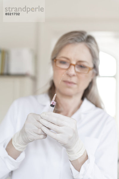 Alternativer weiblicher Praktiker bei der Vorbereitung der Injektionsspritze
