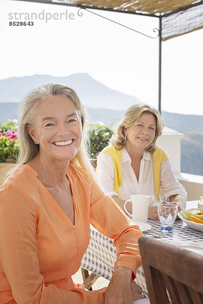 Seniorinnen bei Tisch auf dem Balkon