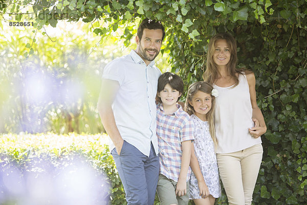 Familie lächelt unter Efeu