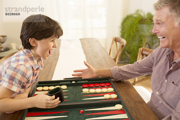 Großvater und Enkel beim Backgammon spielen