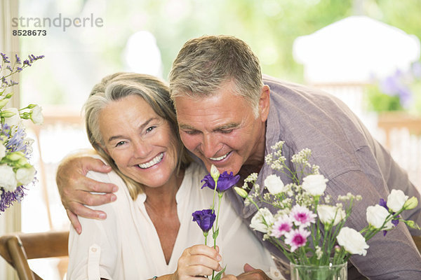 Seniorenpaar riecht Blumen