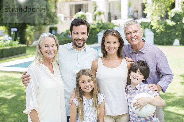 Mehrgenerationen-Familie lächelt im Hinterhof