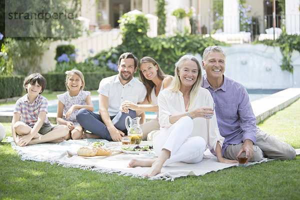 Mehrgenerationen-Familie beim Picknick im Garten