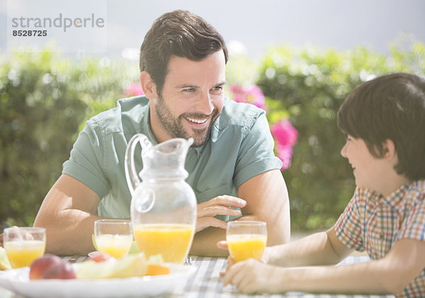 Vater und Sohn beim Frühstück im Freien