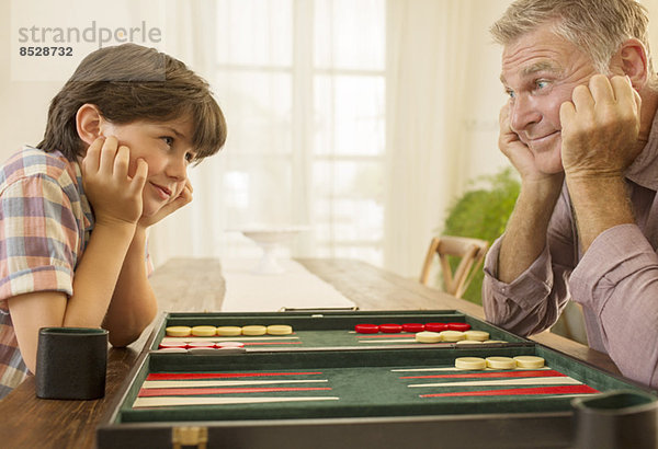 Großvater und Enkel beim Backgammon spielen