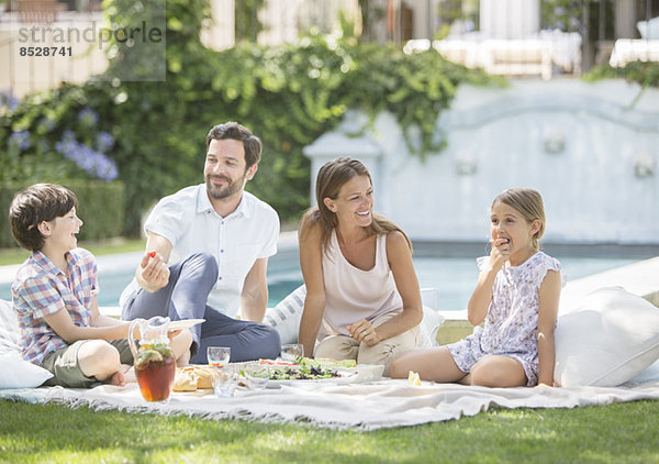 Familie genießt Picknick im Gras