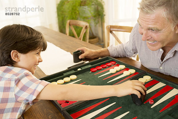 Großvater und Enkel beim Backgammon spielen