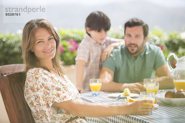 Frau lächelt am Terrassentisch