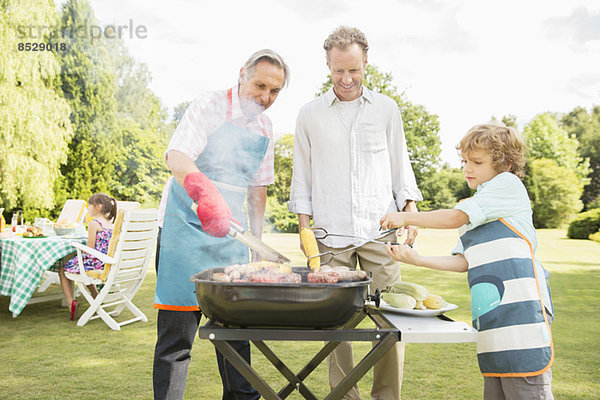 Männer grillen Fleisch auf dem Grill im Hinterhof