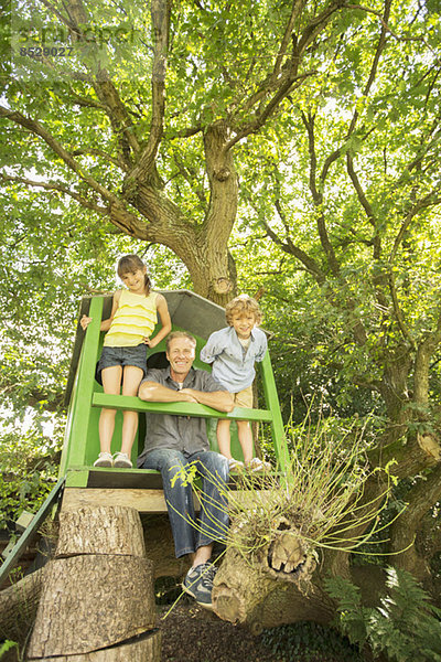 Vater und Kinder spielen im Baumhaus