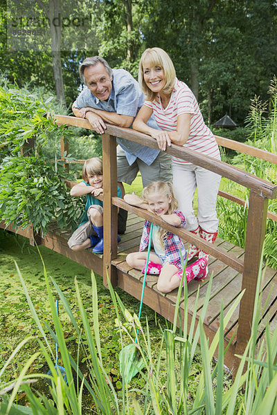 Großeltern und Enkelkinder lächelnd auf Holzsteg