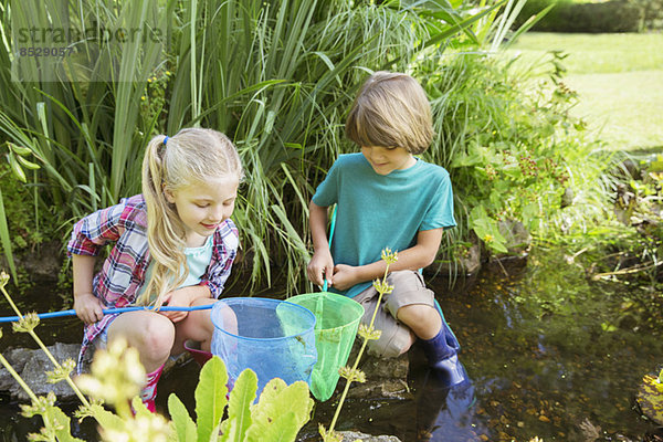 Kinder beim gemeinsamen Fischen im Teich