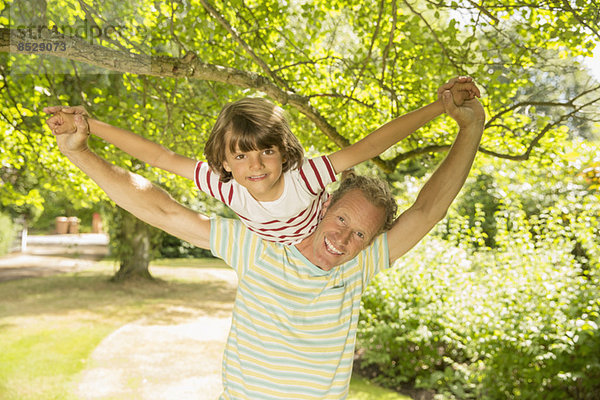 Vater Huckepack-Sohn unter Baum