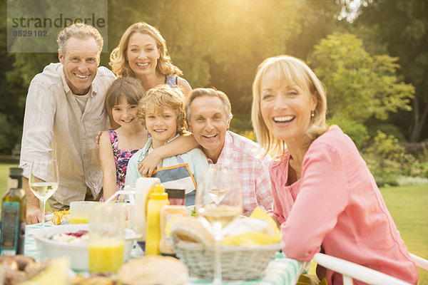 Mehrgenerationen-Familie am Tisch im Hinterhof