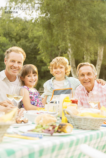 Mehrgenerationen-Familienessen am Tisch im Hinterhof