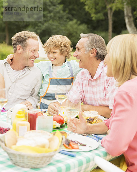 Familie genießt Mittagessen am Tisch im Hinterhof