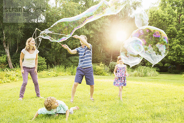 Familienspiel mit großen Blasen im Hinterhof