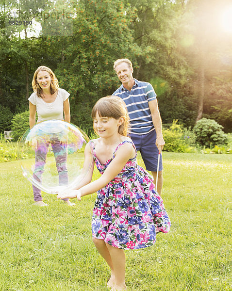 Familienspiel mit Blasen im Garten