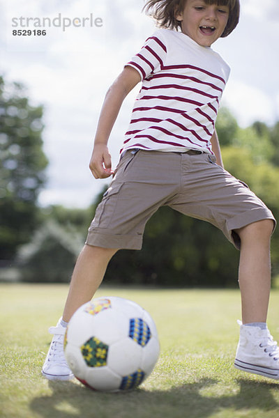 Junge spielt Fußball im Freien