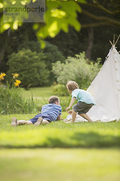 Vater und Sohn liegen außerhalb des Tipis.