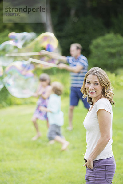 Familienspiel mit Blasen im Garten