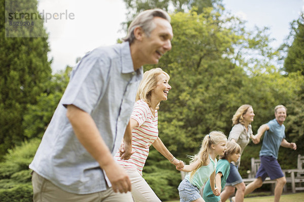 Mehrgenerationen-Familie beim Händchenhalten und Laufen