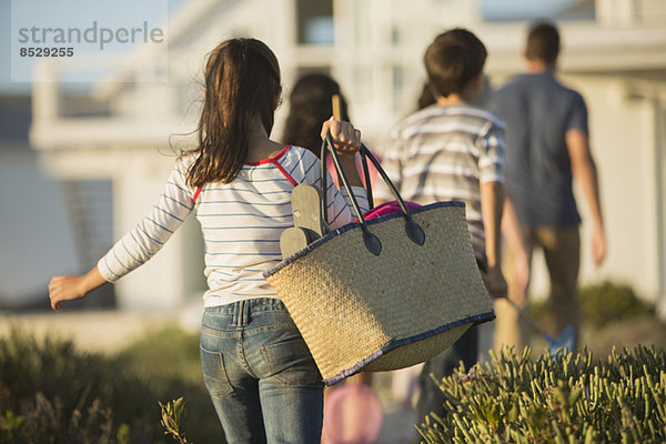 Mädchen mit Strandtasche nach Familie