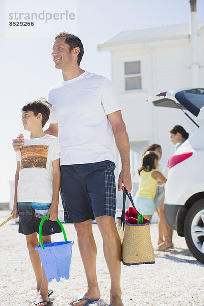 Vater und Sohn halten die Strandkleidung mit dem Auto.