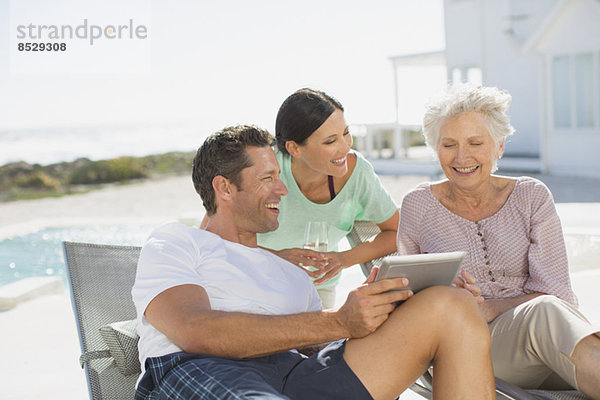 Familie mit digitalem Tablett am Pool
