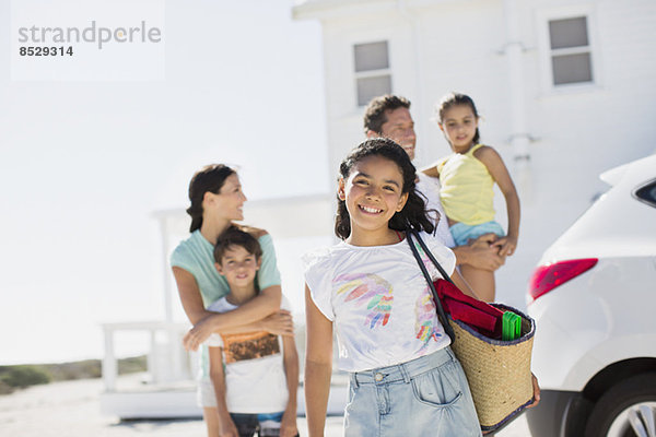 Familie lächelt in sonniger Einfahrt