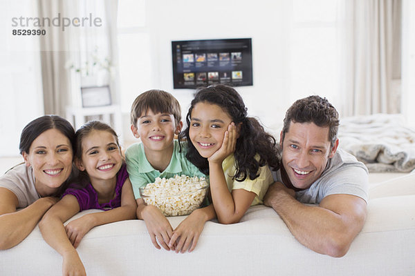 Familie entspannt gemeinsam auf dem Sofa im Wohnzimmer