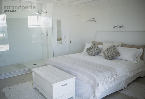 Bett  Dusche und Kofferraum im modernen Schlafzimmer