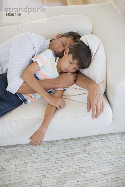 Vater und Sohn schlafend auf Sofa im Wohnzimmer