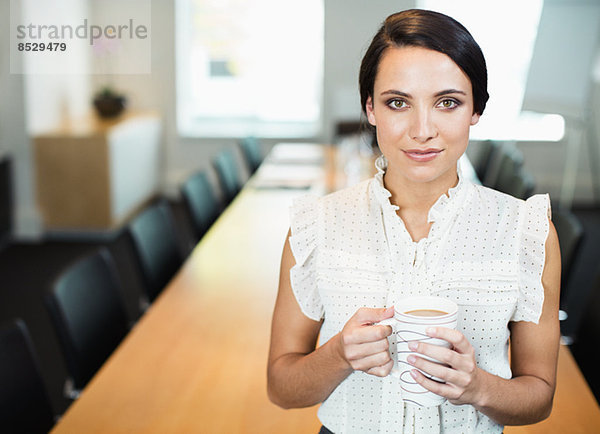 Geschäftsfrau trinkt eine Tasse Kaffee im Konferenzraum