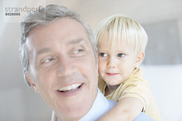 Vater trägt Kleinkind Sohn Huckepack