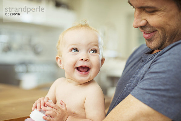 Vater hält Baby in der Küche