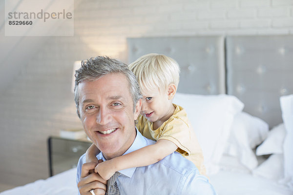 Vater trägt Sohn Huckepack