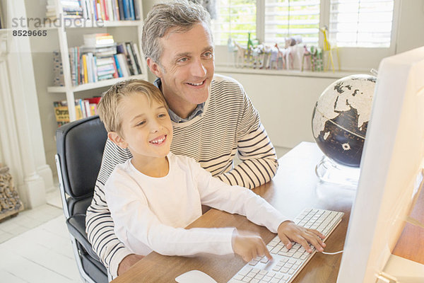 Vater und Sohn nutzen gemeinsam den Computer