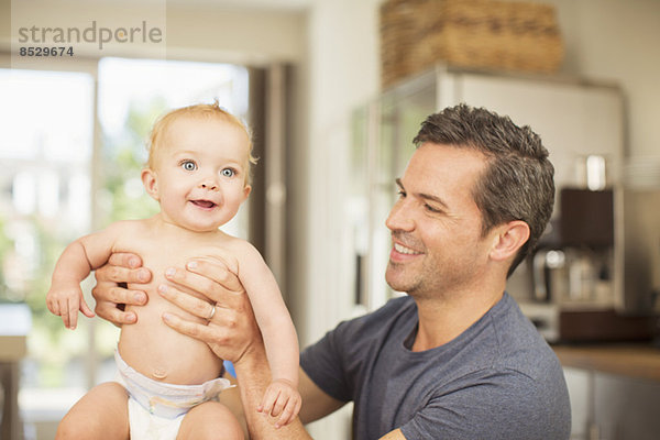 Vater hält Baby in der Küche