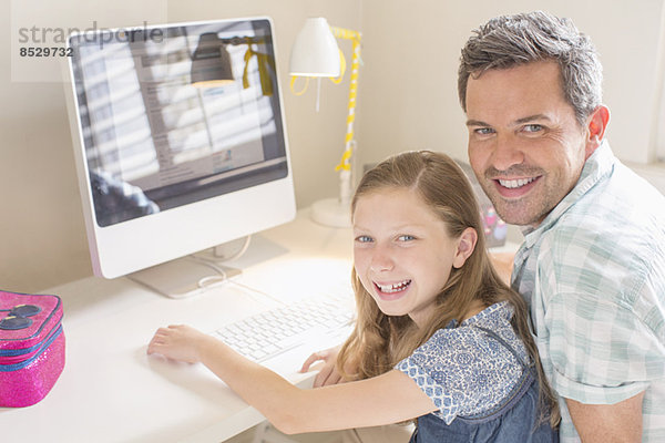 Vater und Tochter nutzen gemeinsam den Computer