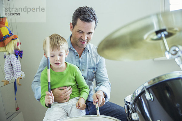 Vater und Sohn spielen gemeinsam Schlagzeug