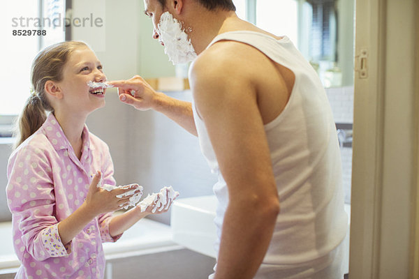 Vater und Tochter spielen mit Rasiercreme