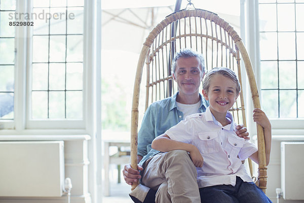 Vater und Sohn sitzen im Korbsessel