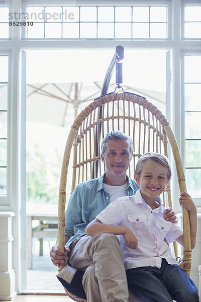 Vater und Sohn sitzen im Korbsessel